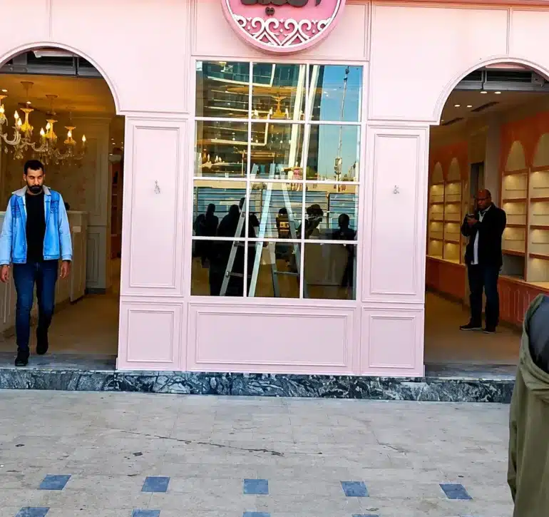 الواجهة الكلاسيكية ذات اللون الوردي والديكورات الفاخرة لفرع حلواني العبد مزودة بحلول تأمين الأبواب والمداخل من جاتكس